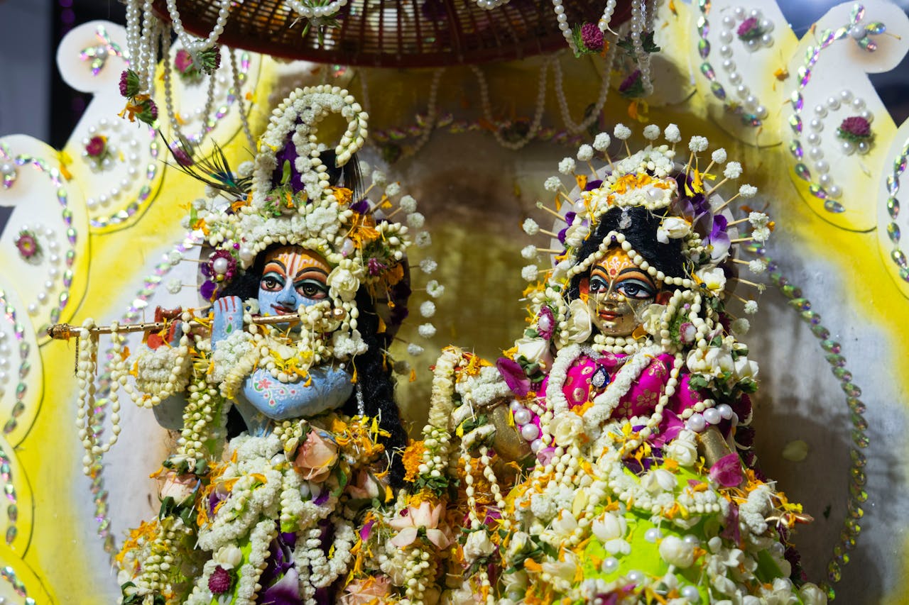 Vibrant Hindu deities statues embellished with floral decorations, symbolizing spiritual reverence.